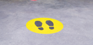 Pavement with a yellow circle with footprints in the middle
